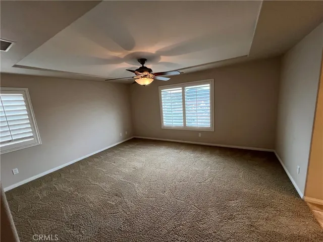 an empty room with a window and a ceiling fan