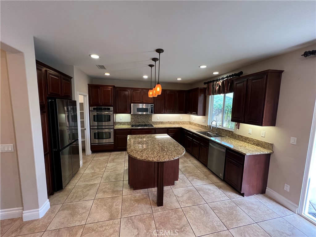 35429 Saddle Hill Road Lake Elsinore, CA 92532 - Photo 7 of 27 a kitchen with stainless steel appliances granite countertop a sink counter space cabinets and a view of kitchen