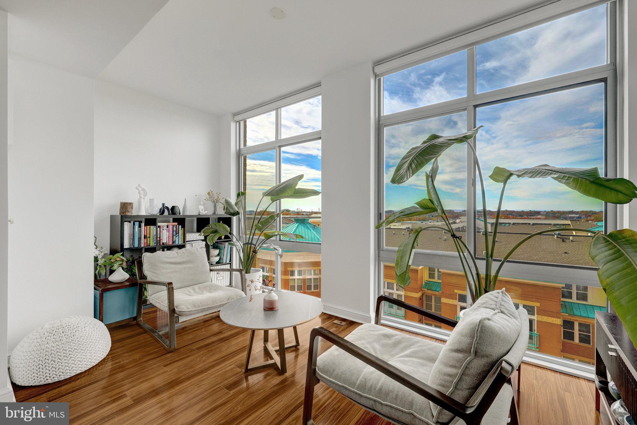 a living room with furniture and a floor to ceiling window