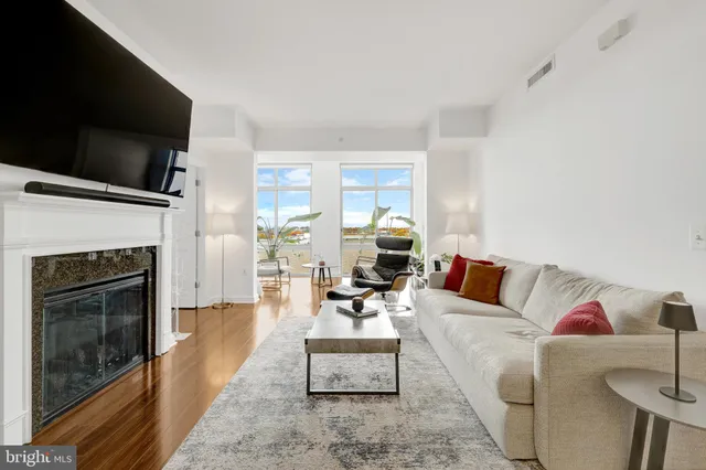 a living room with furniture a flat screen tv and a fireplace