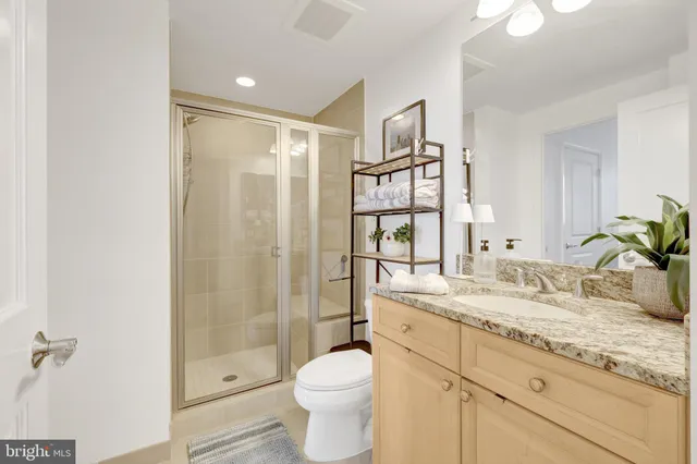 a bathroom with a granite countertop sink toilet and shower