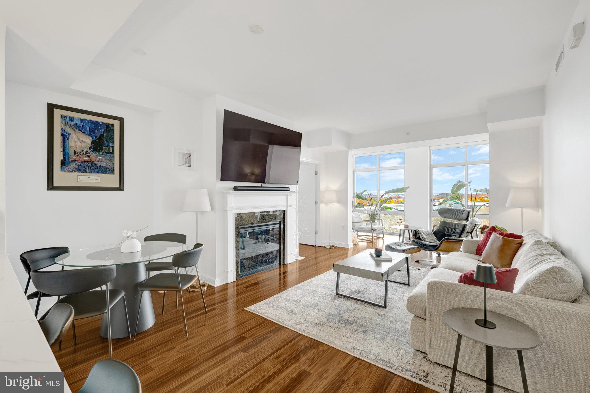 11990 Market Street, Unit 614 Reston, VA 20190 - Photo 3 of 43 a living room with furniture a fireplace and a flat screen tv