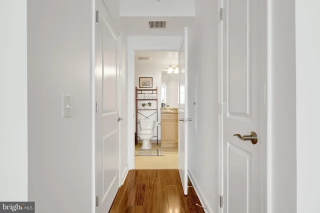 a view of a hallway with wooden floor and closet
