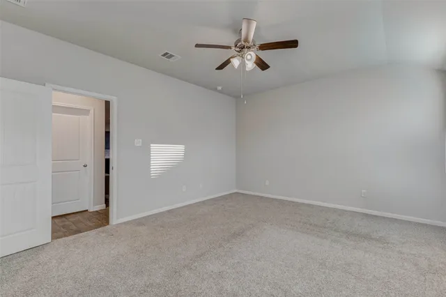 an empty room with a ceiling fan and a window