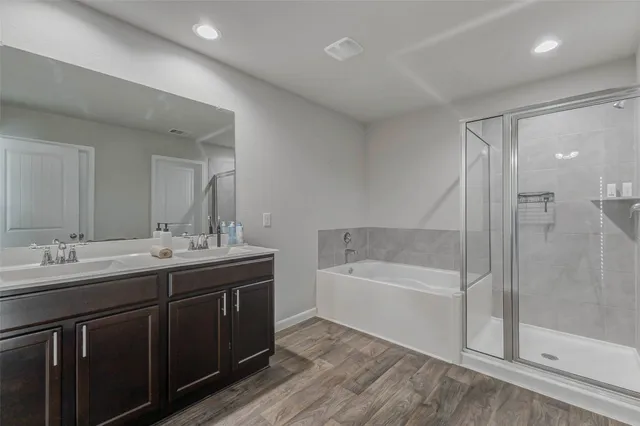 a bathroom with a tub double sink and mirror