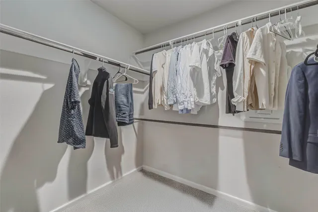 a view of walk in closet with clothes and shoes