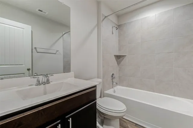 a bathroom with a sink a toilet a mirror and shower