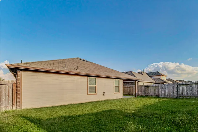 a backyard of a house with lots of green space and trampoline