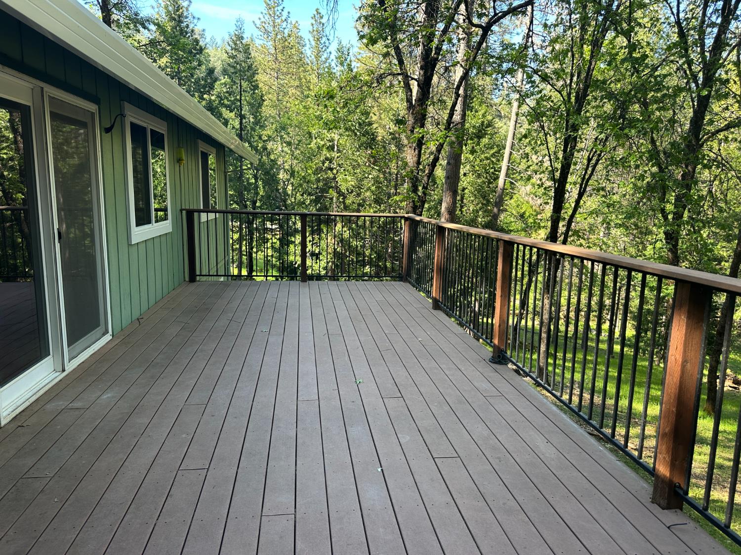 5570 5 Spot Road Placerville, CA 95667 - Photo 10 of 38 a balcony with wooden floor and trees in the back