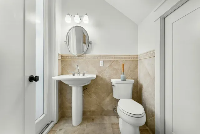 a bathroom with a double vanity sink toilet mirror and shower