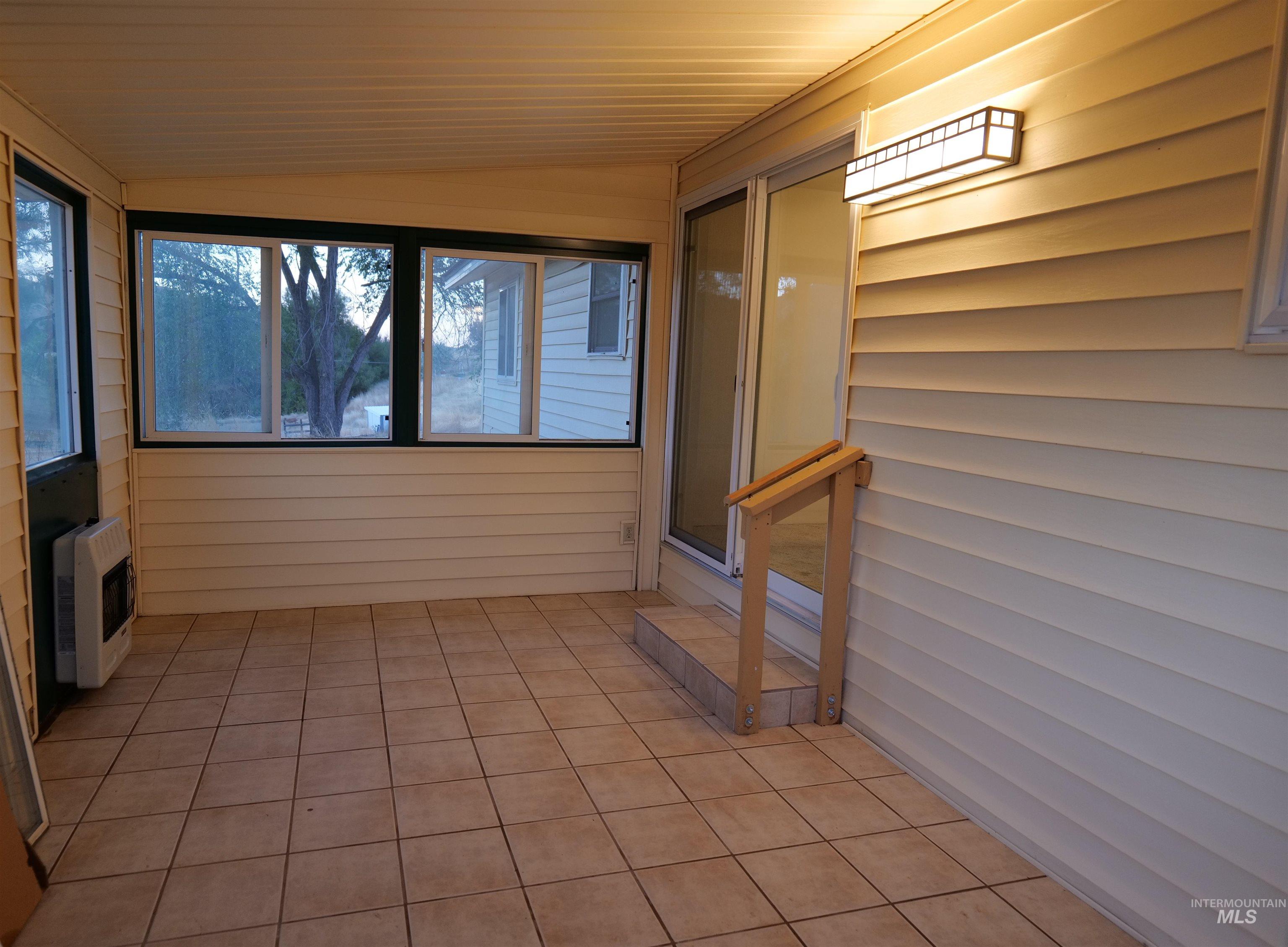 1485 East 9th Street Weiser, ID 83672 - Photo 8 of 18 Enclosed sunroom featuring light-toned tile flooring, horizontal vinyl siding, and multiple windows