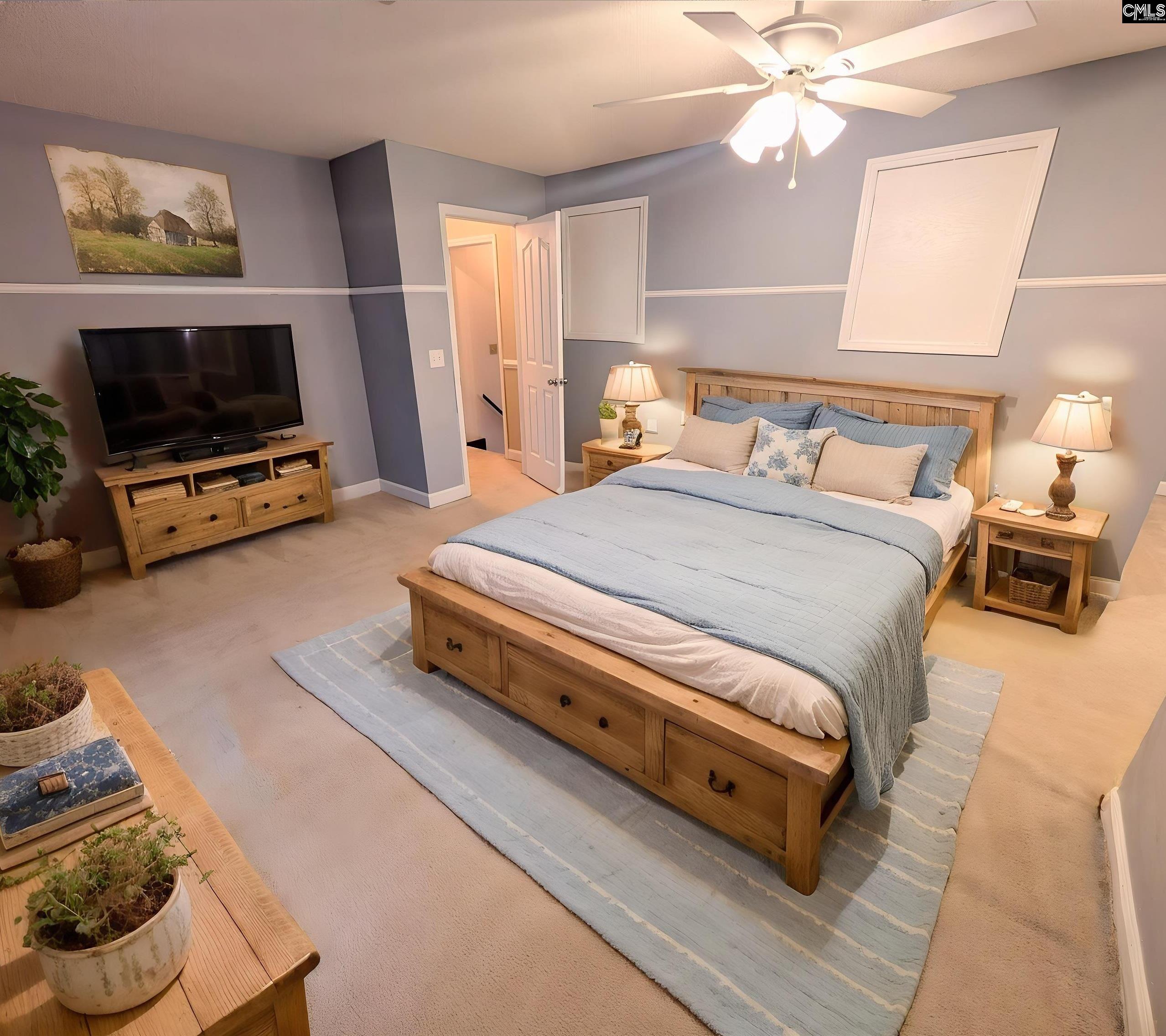 100 Welsh Court Lexington, SC 29073 - Photo 18 of 27 a spacious bedroom with a bed a flat screen tv and a couch