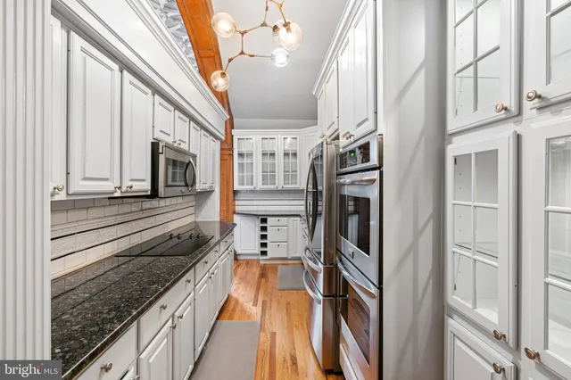 a kitchen with stainless steel appliances granite countertop a refrigerator and a stove