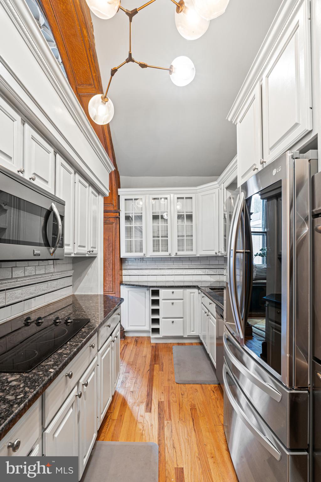 251-59 South 22nd Street, Unit A Philadelphia, PA 19103 - Photo 17 of 37 a kitchen with stainless steel appliances granite countertop a stove and a wooden floors