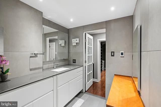 a spacious bathroom with a granite countertop sink and a mirror