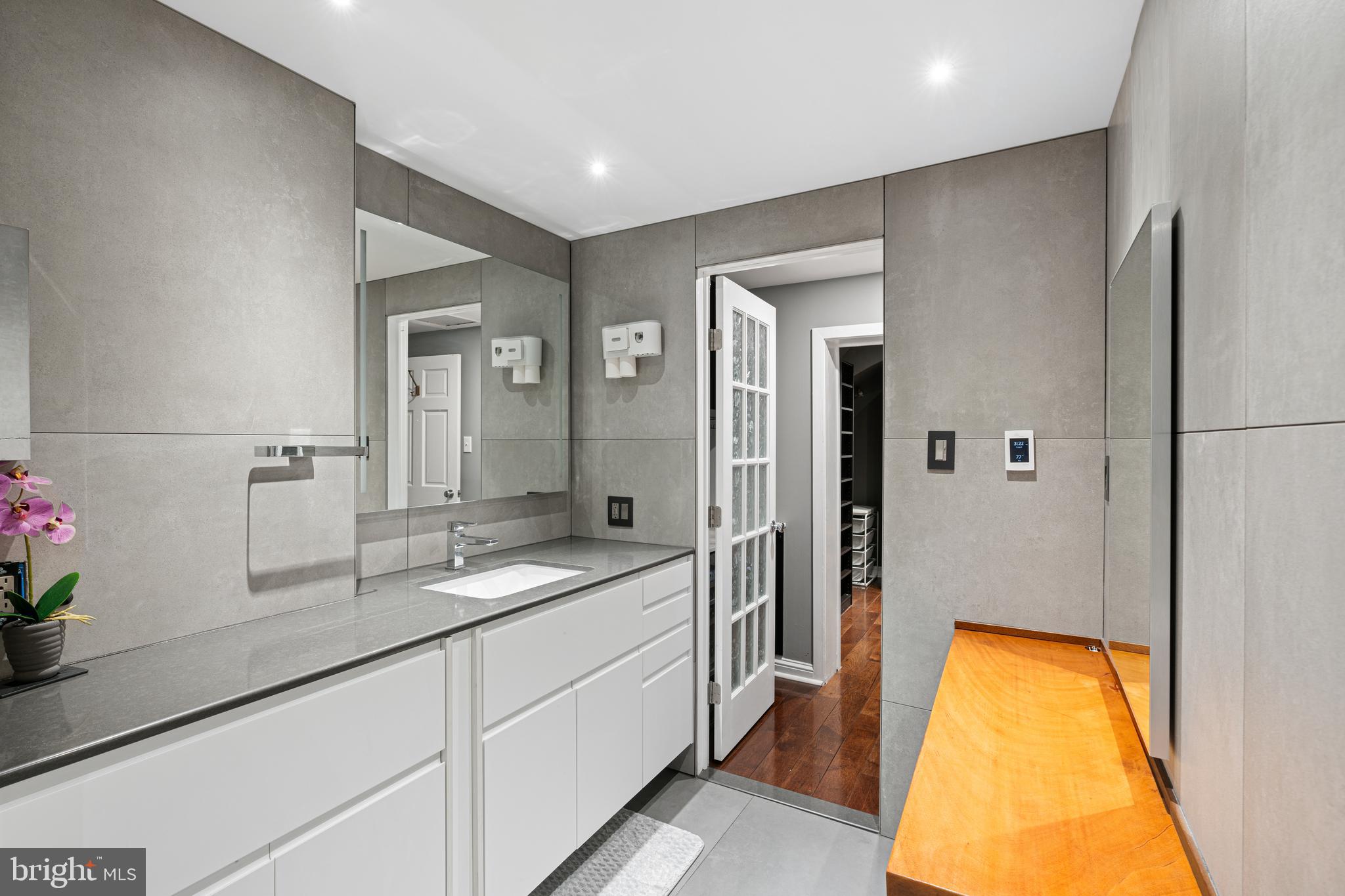 251-59 South 22nd Street, Unit A Philadelphia, PA 19103 - Photo 29 of 37 a spacious bathroom with a granite countertop sink and a mirror