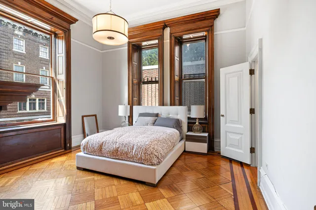 a bedroom with a bed and a dresser next to a window