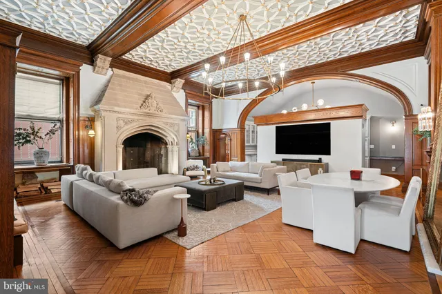 a living room with couches a flat screen tv and kitchen view