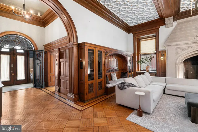 a living room with furniture a fireplace and a chandelier