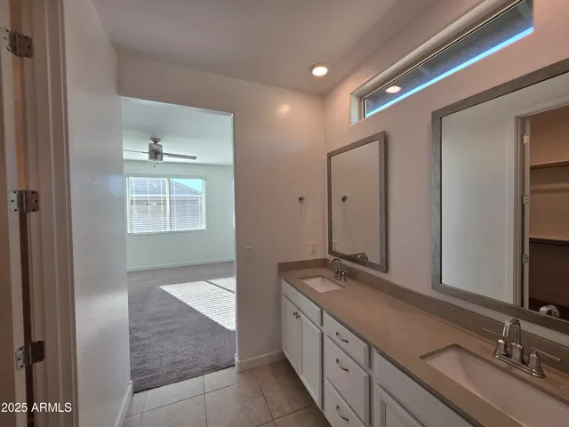 a spacious bathroom with a double vanity sink and a mirror