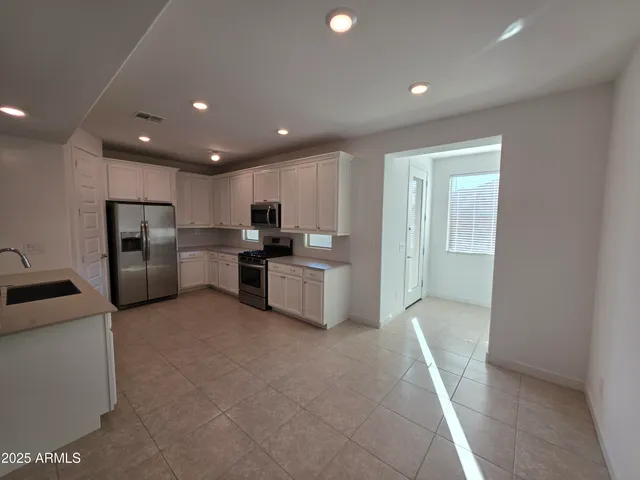 a kitchen with refrigerator and cabinets