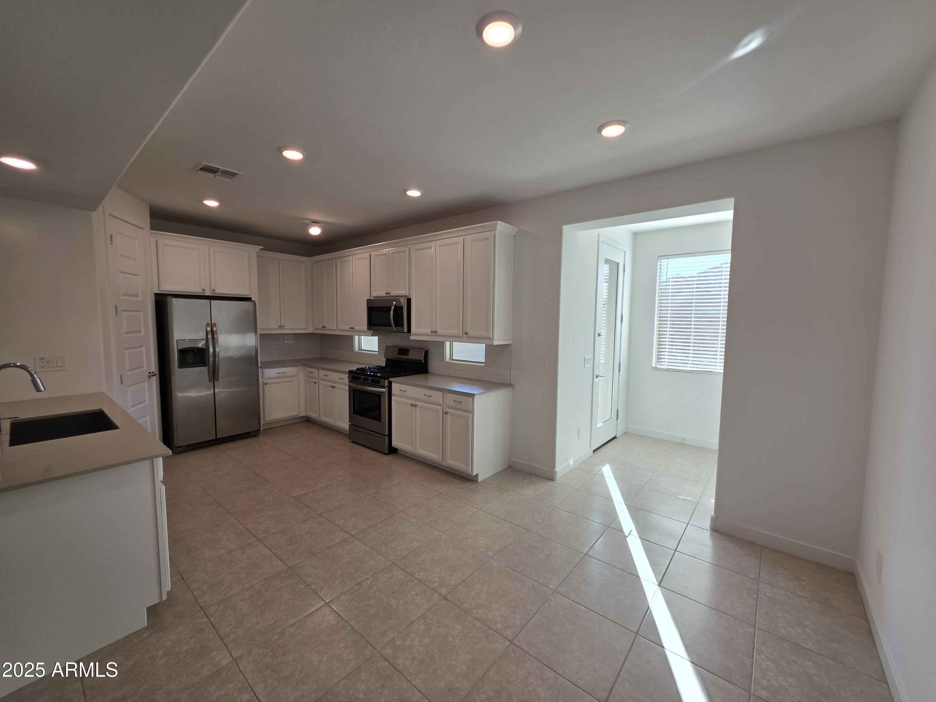 319 Pinnacle Ridge Drive San Tan Valley, AZ 85140 - Photo 3 of 25 a kitchen with refrigerator and cabinets