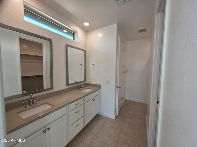 a spacious bathroom with a double vanity sink and mirror