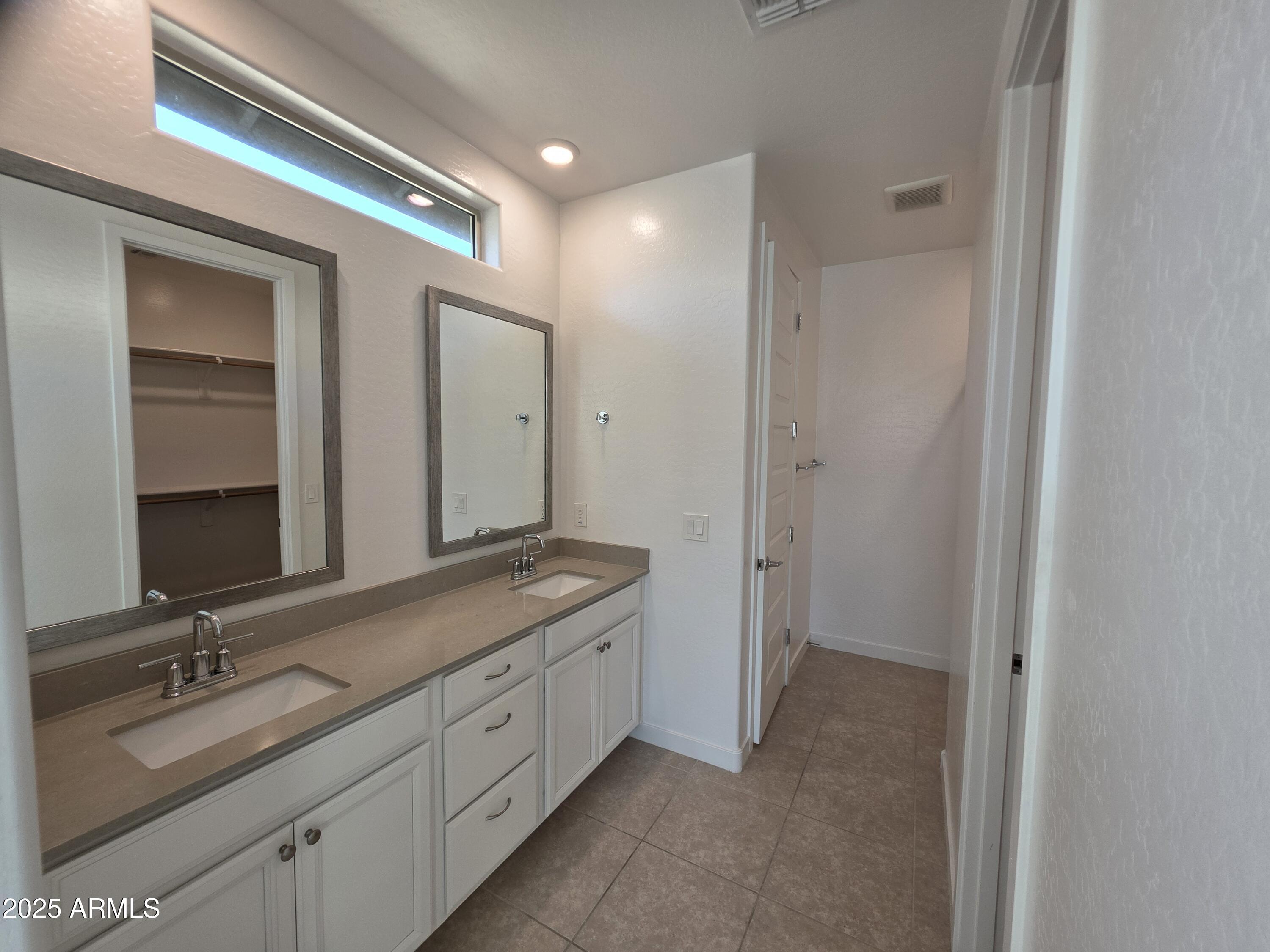 319 Pinnacle Ridge Drive San Tan Valley, AZ 85140 - Photo 10 of 25 a spacious bathroom with a double vanity sink and mirror