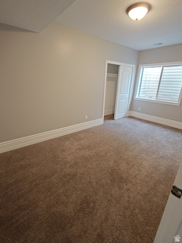 552 Sunset Crest Way Draper, UT 84020 - Photo 53 of 68 Unfurnished bedroom with a closet, light colored carpet, and a textured ceiling