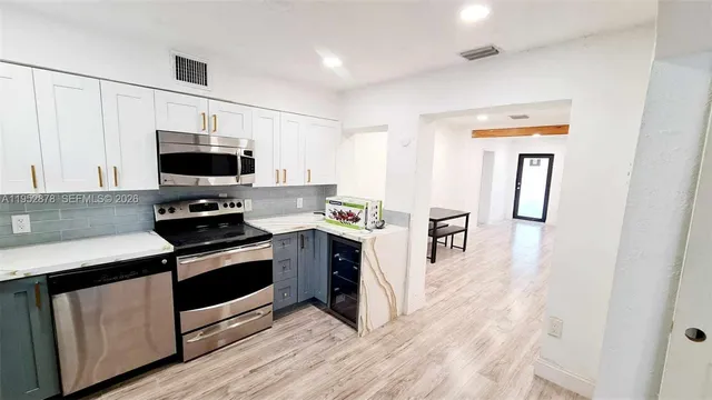 a kitchen with stainless steel appliances a stove microwave and sink
