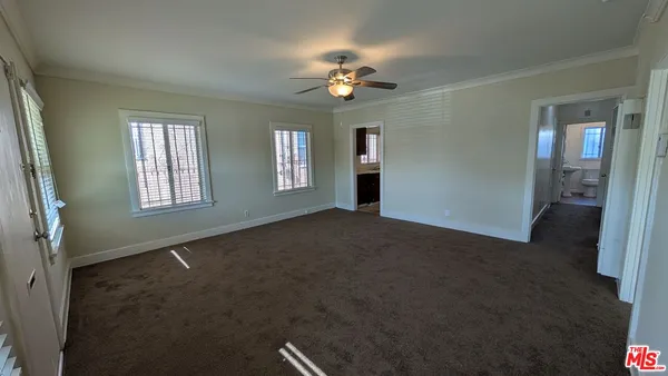 a view of a livingroom with a ceiling fan and window