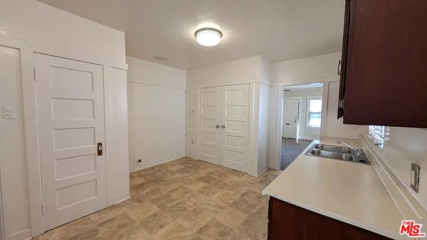 a view of a kitchen cabinets a sink dishwasher and a stove top oven with wooden floor