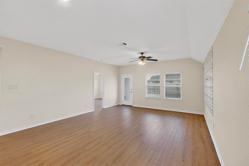 408 Rawhide Way Princeton, TX 75407 - Photo 5 of 36 a view of an empty room with wooden floor and a window