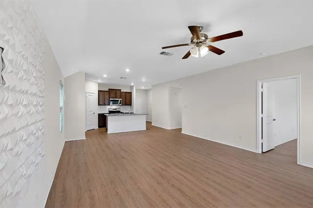 a kitchen with stainless steel appliances granite countertop a stove top oven a sink dishwasher a refrigerator and a oven with wooden floor