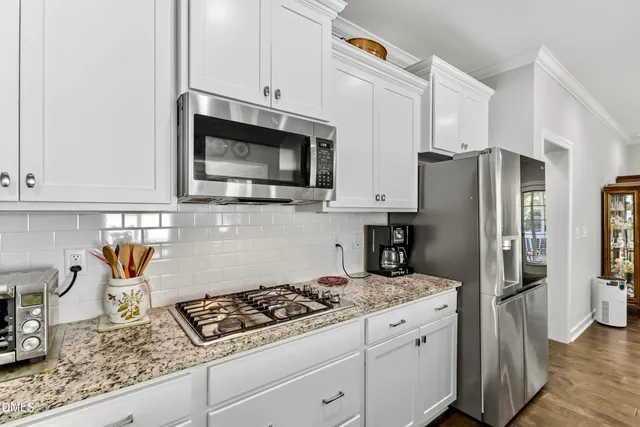 a kitchen with stainless steel appliances granite countertop a refrigerator stove and sink