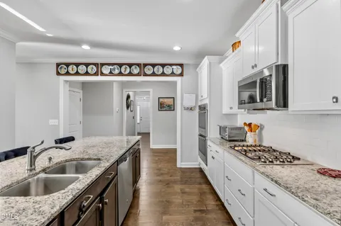 a kitchen with granite countertop a sink and a stove top oven