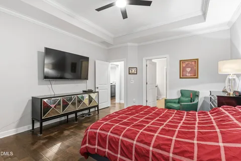 a bedroom with a bed and a flat tv screen on dresser