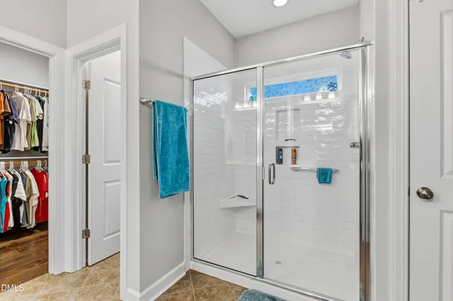 a bathroom with a glass shower door and a glass door shower