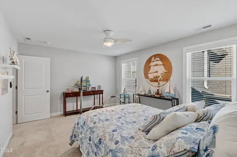 a bedroom with a bed a dresser and chair