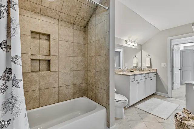 a bathroom with a granite countertop sink a toilet and shower