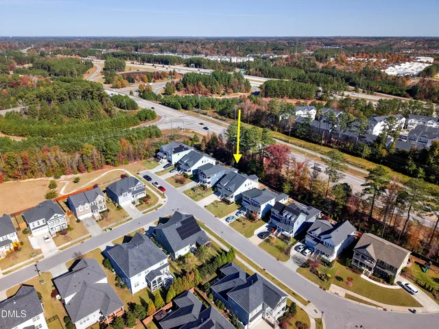 a view of a house with street next to a large tree