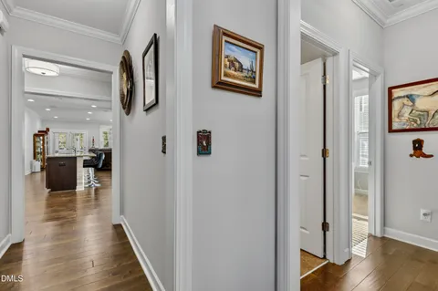 a view of a hallway with wooden floor and dining room