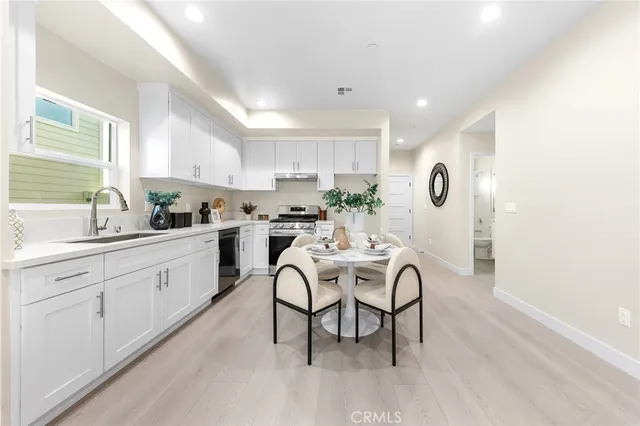 a kitchen with granite countertop white cabinets dining table and chairs