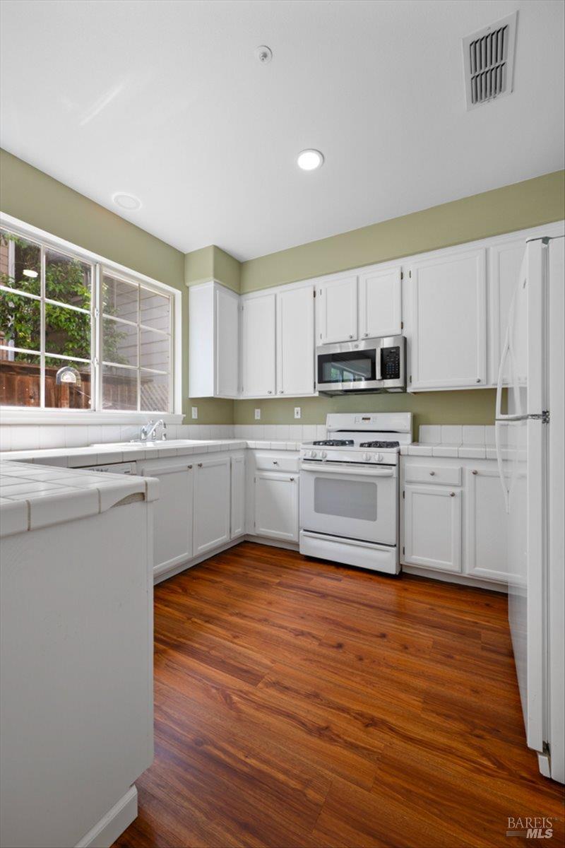 1028 Addison Circle Petaluma, CA 94952 - Photo 16 of 60 a kitchen with wooden floors a sink stainless steel appliances and window