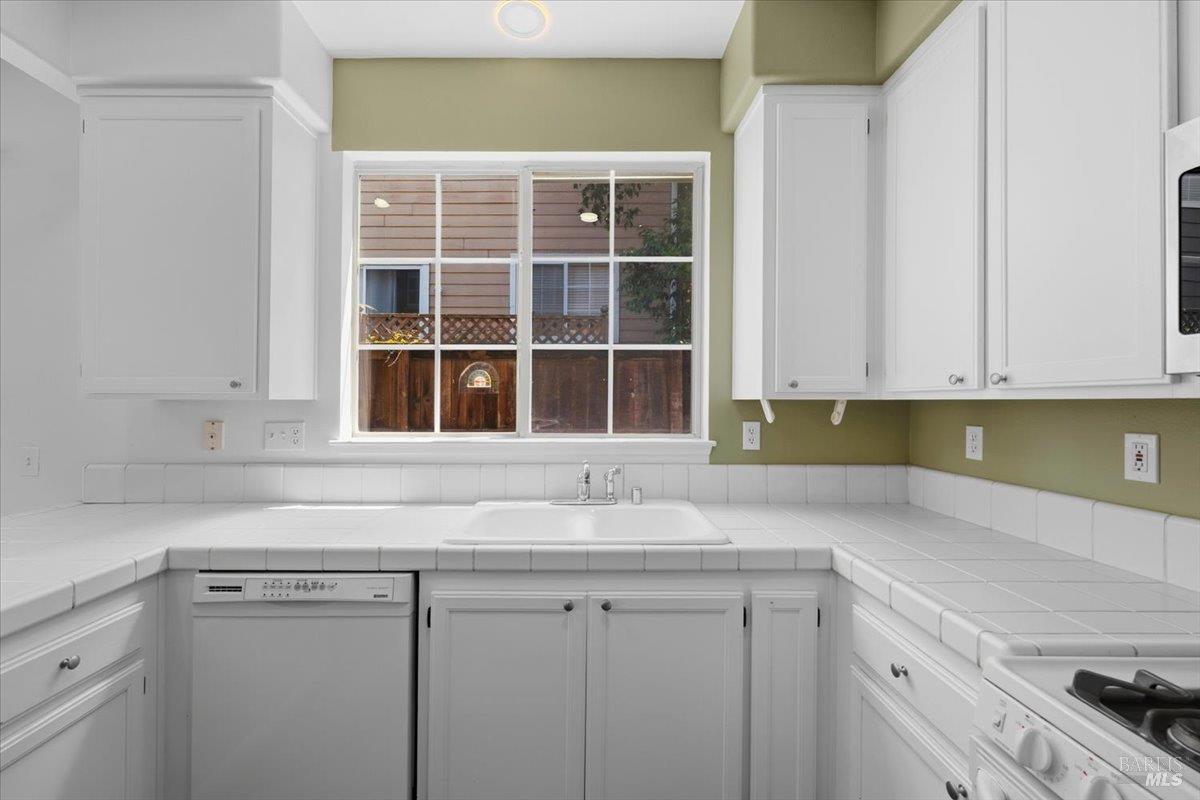 1028 Addison Circle Petaluma, CA 94952 - Photo 19 of 60 a kitchen with granite countertop white cabinets and window