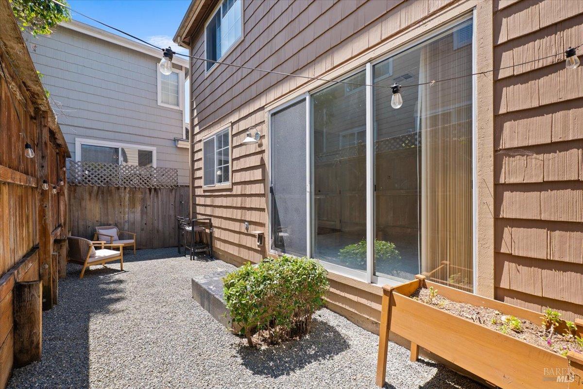 1028 Addison Circle Petaluma, CA 94952 - Photo 41 of 60 a view of a patio with a table and chairs and floor to ceiling window and wooden fence