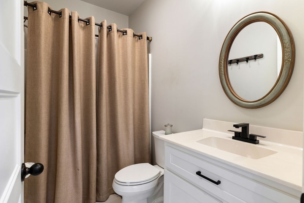 411 Bumpas Road Lawrenceburg, TN 38464 - Photo 18 of 30 a bathroom with a sink a mirror a toilet and a mirror