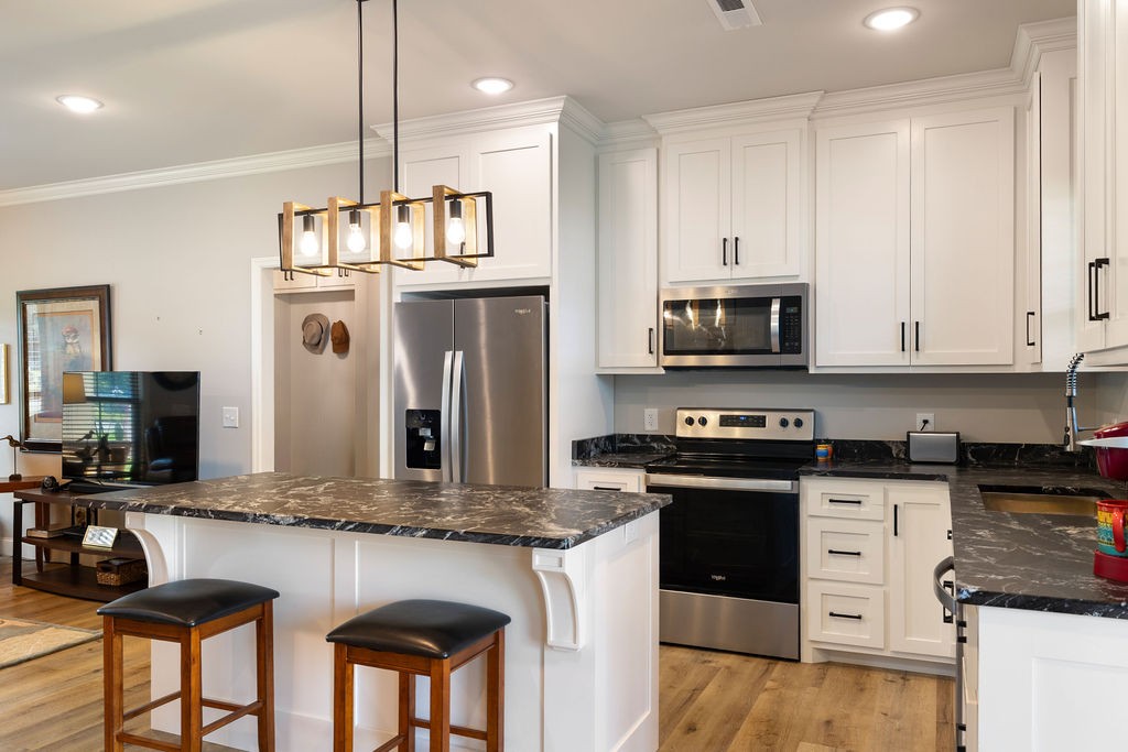 411 Bumpas Road Lawrenceburg, TN 38464 - Photo 10 of 30 a kitchen with stainless steel appliances granite countertop a stove a sink and a refrigerator