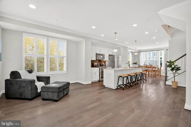 a kitchen with stainless steel appliances granite countertop sink refrigerator dining table and chairs