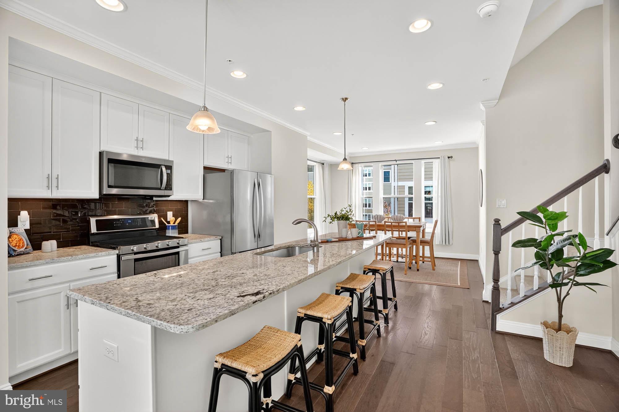 606 James Walker Place Annapolis, MD 21401 - Photo 17 of 52 a kitchen with stainless steel appliances granite countertop sink stove refrigerator dining table and chairs